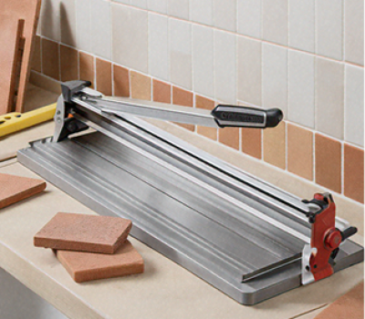 A tile cutter with a sharp blade and a sturdy base positioned on a workbench surrounded by tiles, illustrating the 'Cortador de Azulejos'.